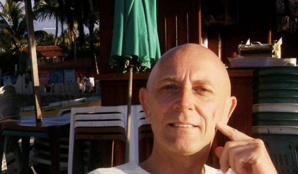 Stefan S. Rohner on a beach in Brazil, smiling, one finger to his cheek